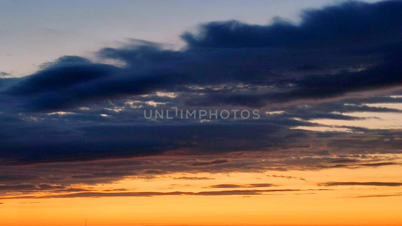 dramatic sky, dark blue clouds on yellow sunset sky by Annado