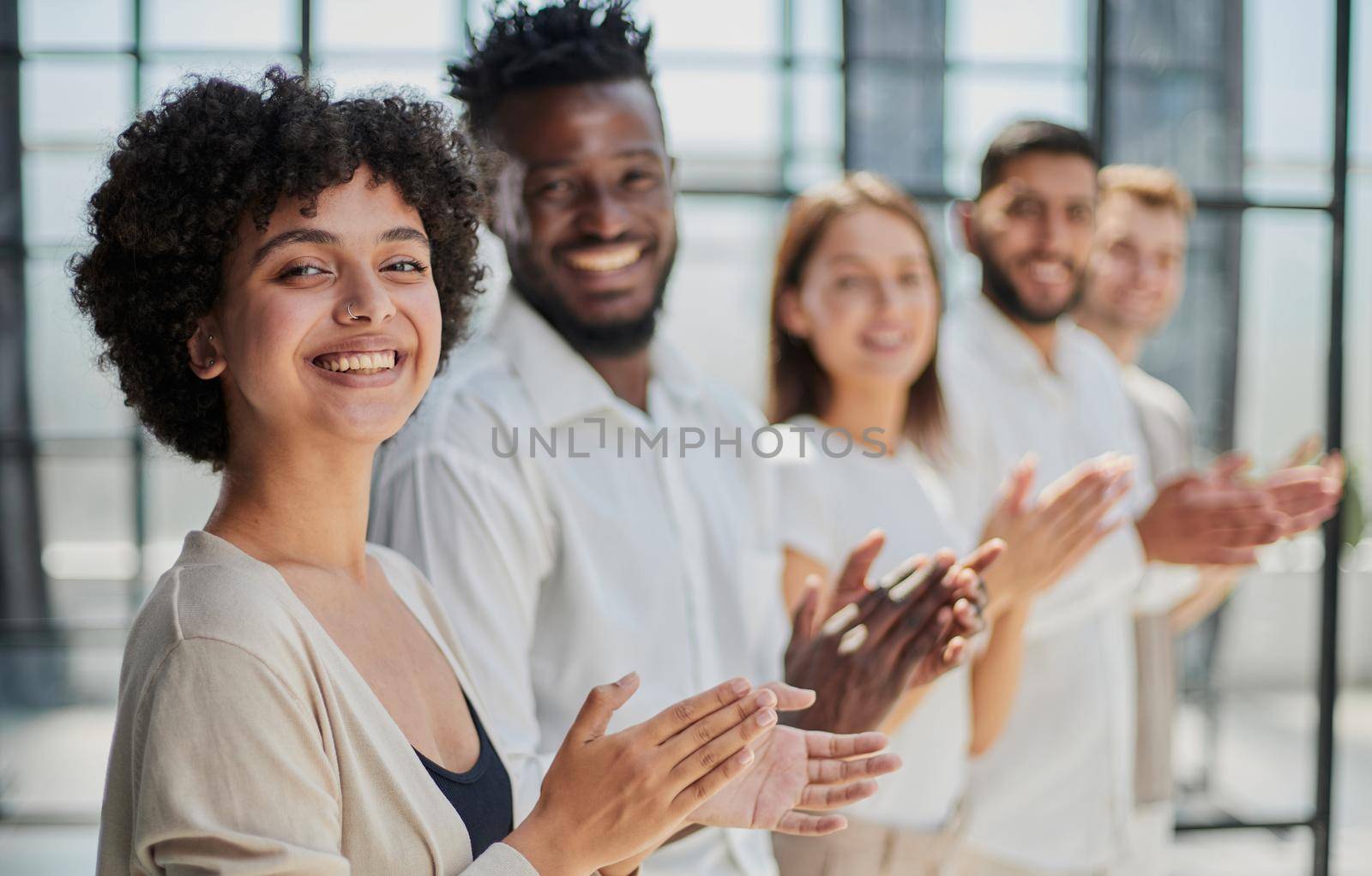 Group of businesspeople sitting in a line and applauding. by Prosto