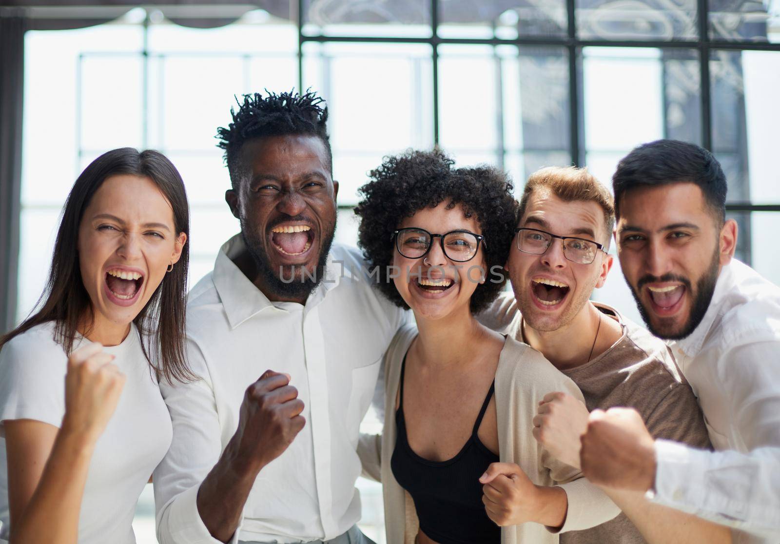 Portrait of successful creative business team looking at camera and smiling. Diverse business people standing together at startup.