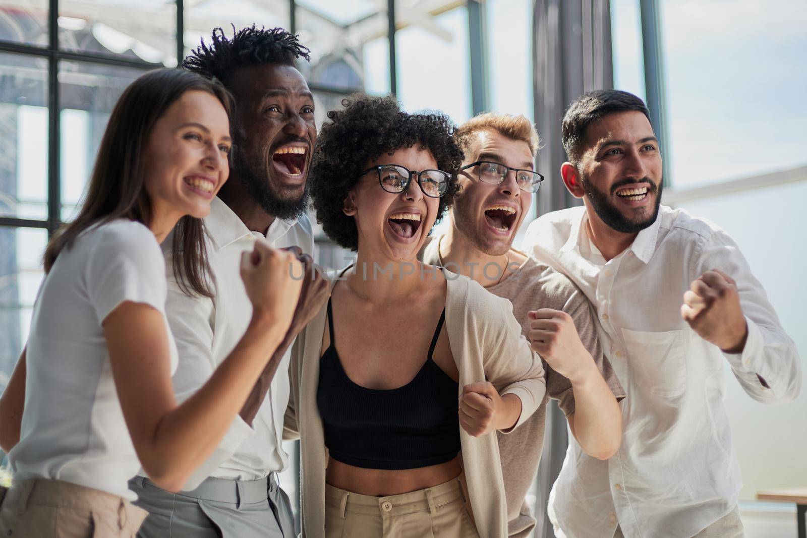 Portrait of successful creative business team looking at camera and smiling. Diverse business people standing together at startup.