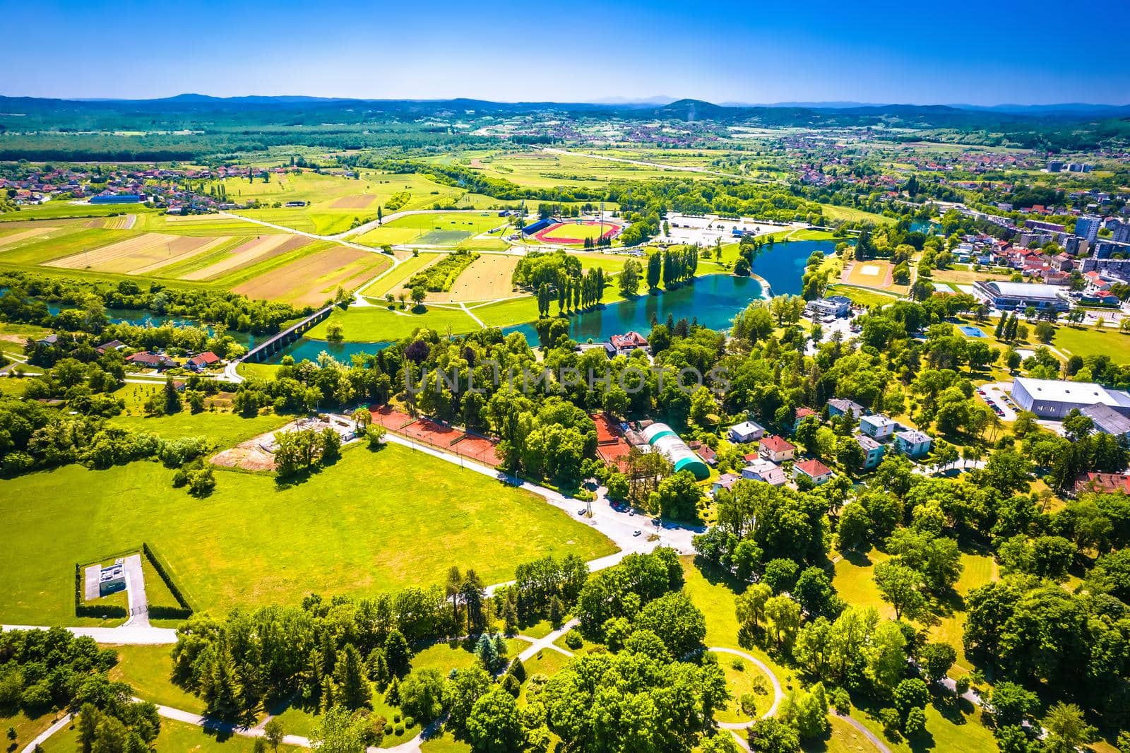 Aerial view of Korana river and green landscape in town of Karlovac by xbrchx