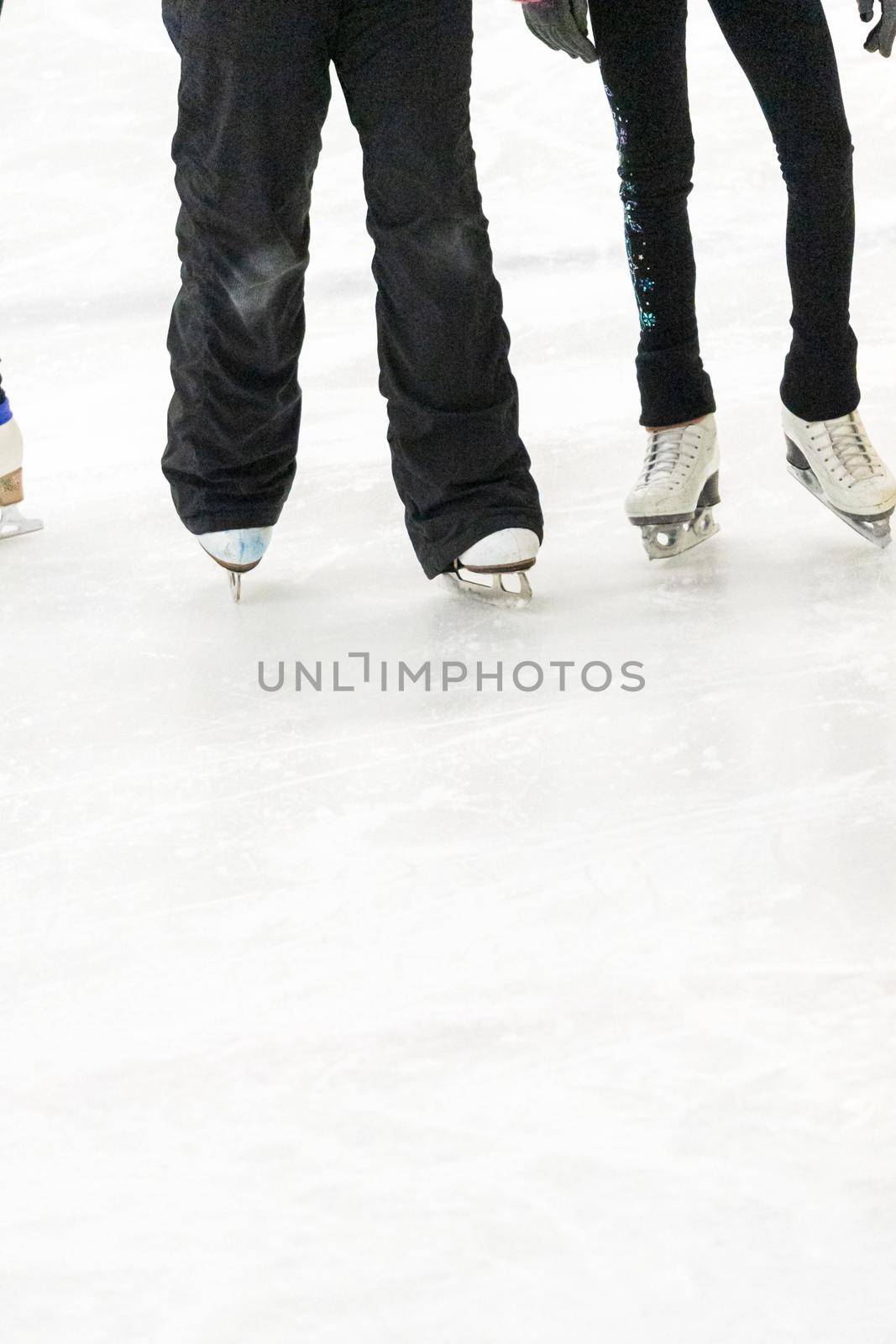View of a figure skater and her coach feet at the figure skating practice.