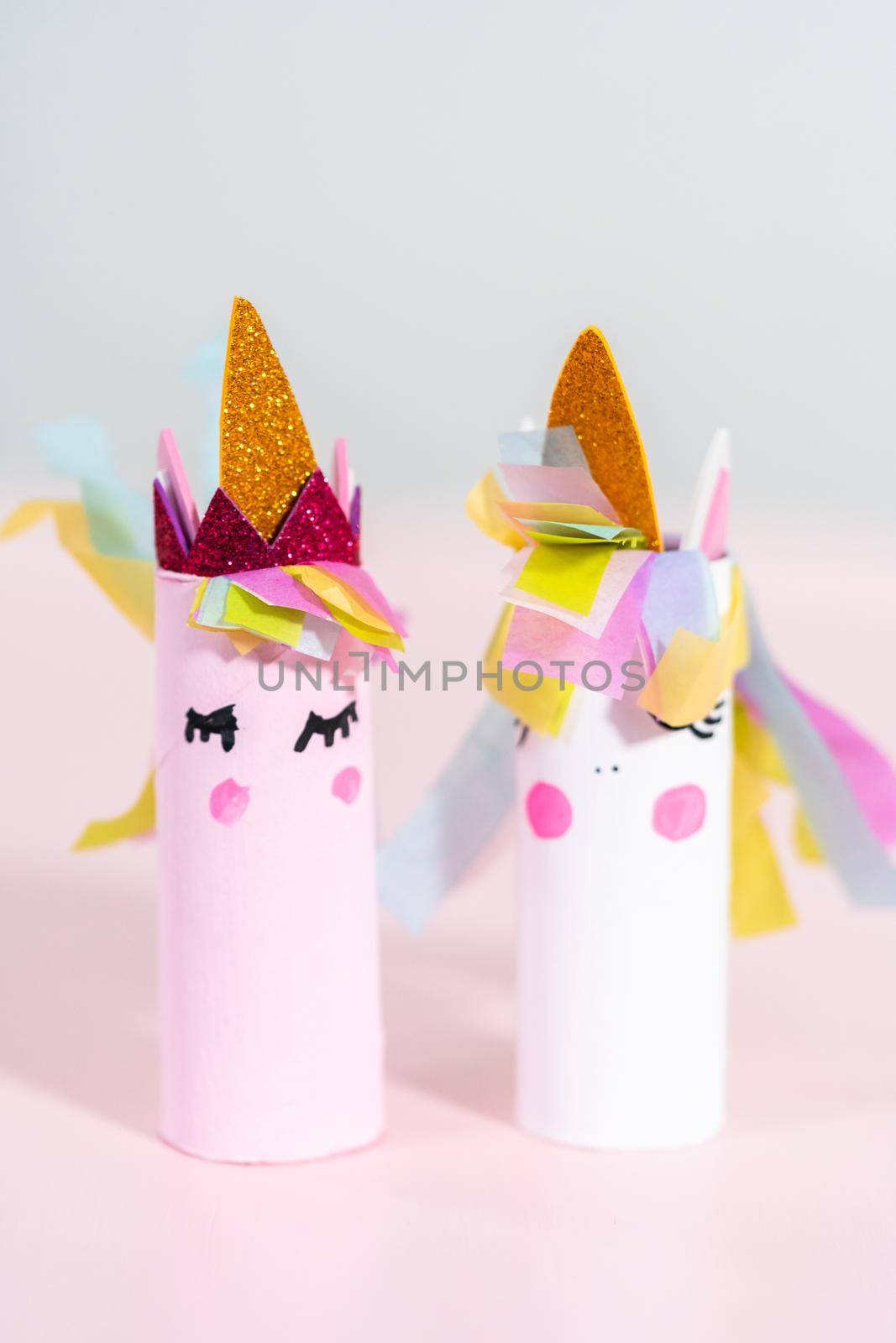 Making a unicorn out of the toilet paper roll and craft paper.