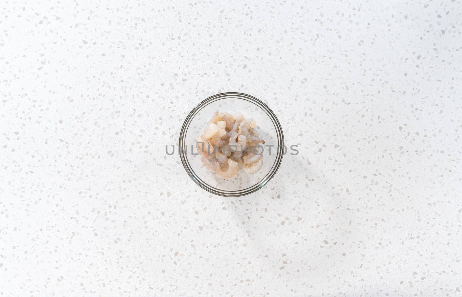 Flat lay. Seasoning raw shrimp to prepare shrimp scampi in the microwave.