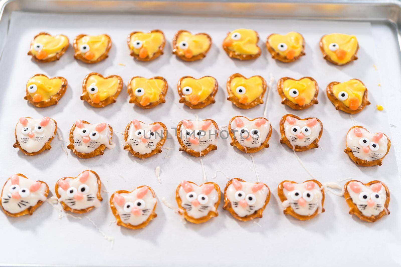 Preparing Easter chocolate-covered pretzel bunnies and ducklings with white and yellow chocolate.