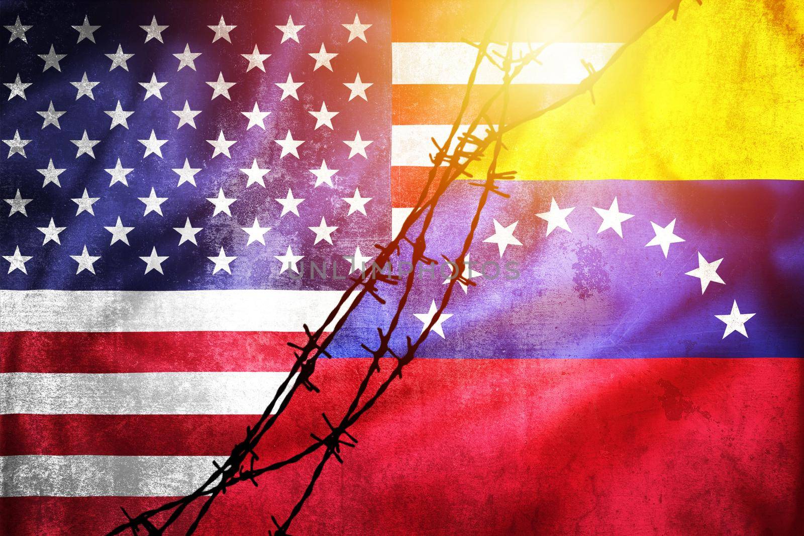 Grunge flags of USA and Venezuela divided by barb wire sun haze illustration, concept of tense relations between USA and Venezuela 
