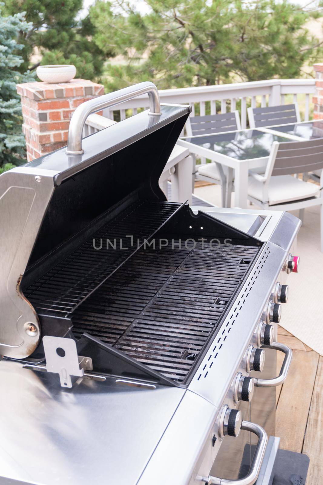 Outdoor six-burner gas grill on the back patio of a luxury single-family home.