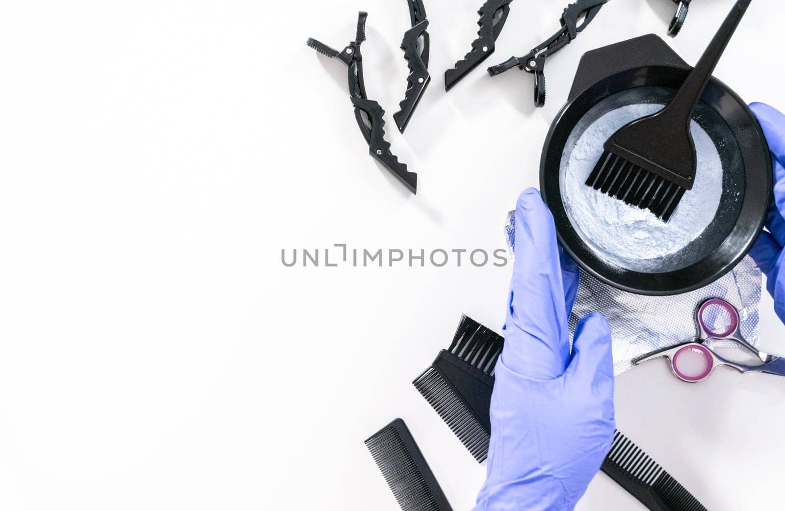 Flat lay. Hair color dye powder in a black plastic mixing bowl on a white background.