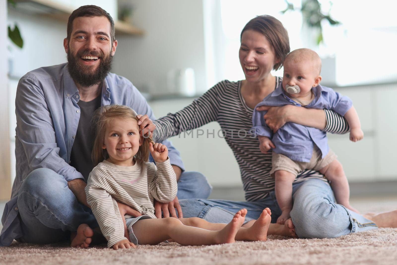 Happy parents playing with children in the kitchen