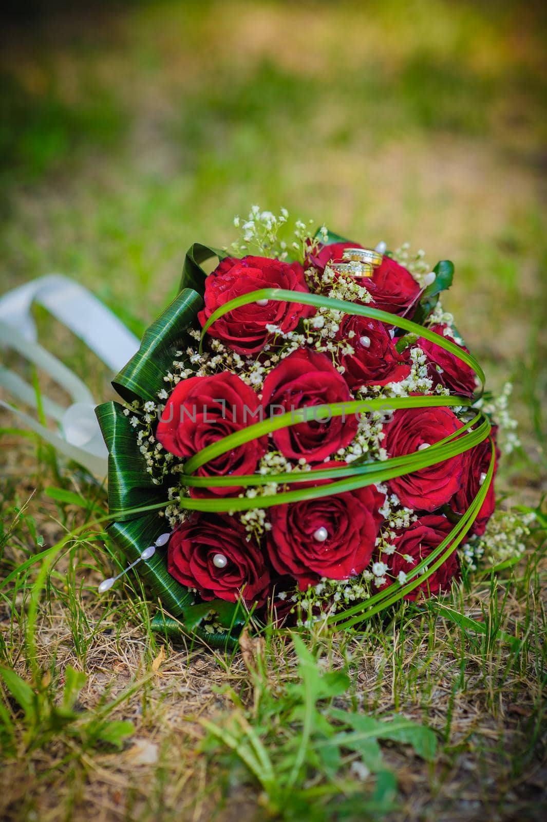 Bridal wedding bouquet of flowers. Wedding bouquet of red roses lying on a grass.