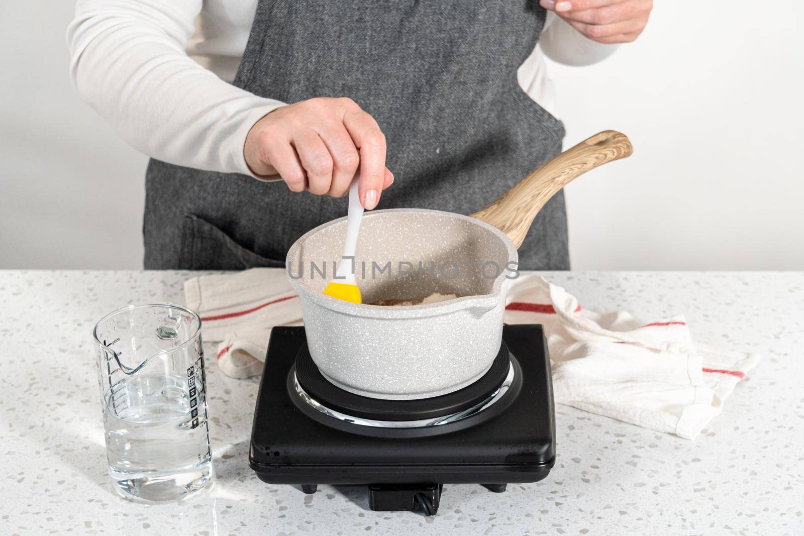 Caramelizing sugar in a saucepan to make caramel cupcake toppers.