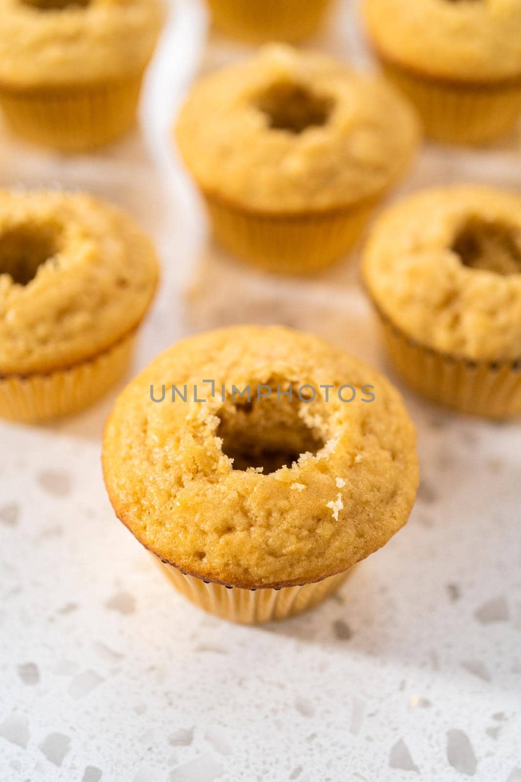 Filling cupcakes with caramel to make dulce de leche cupcakes.