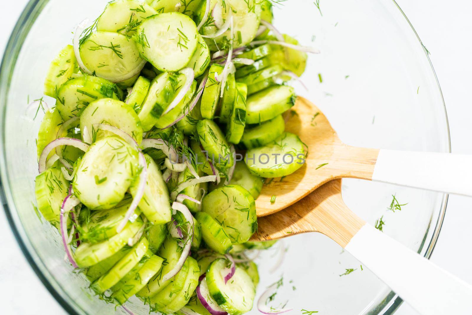 Summer cucumber salad in a large glass mixing bowl.