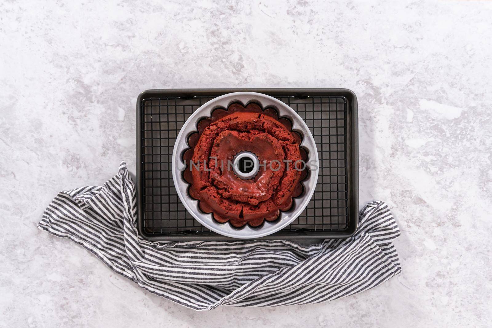 Flat lay. Cooling freshly baked red velvet bundt cake on a kitchen drying rack.