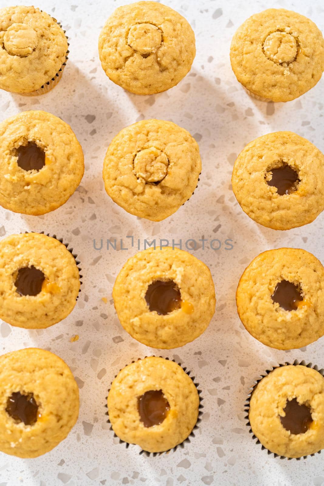 Filling cupcakes with caramel to make dulce de leche cupcakes.