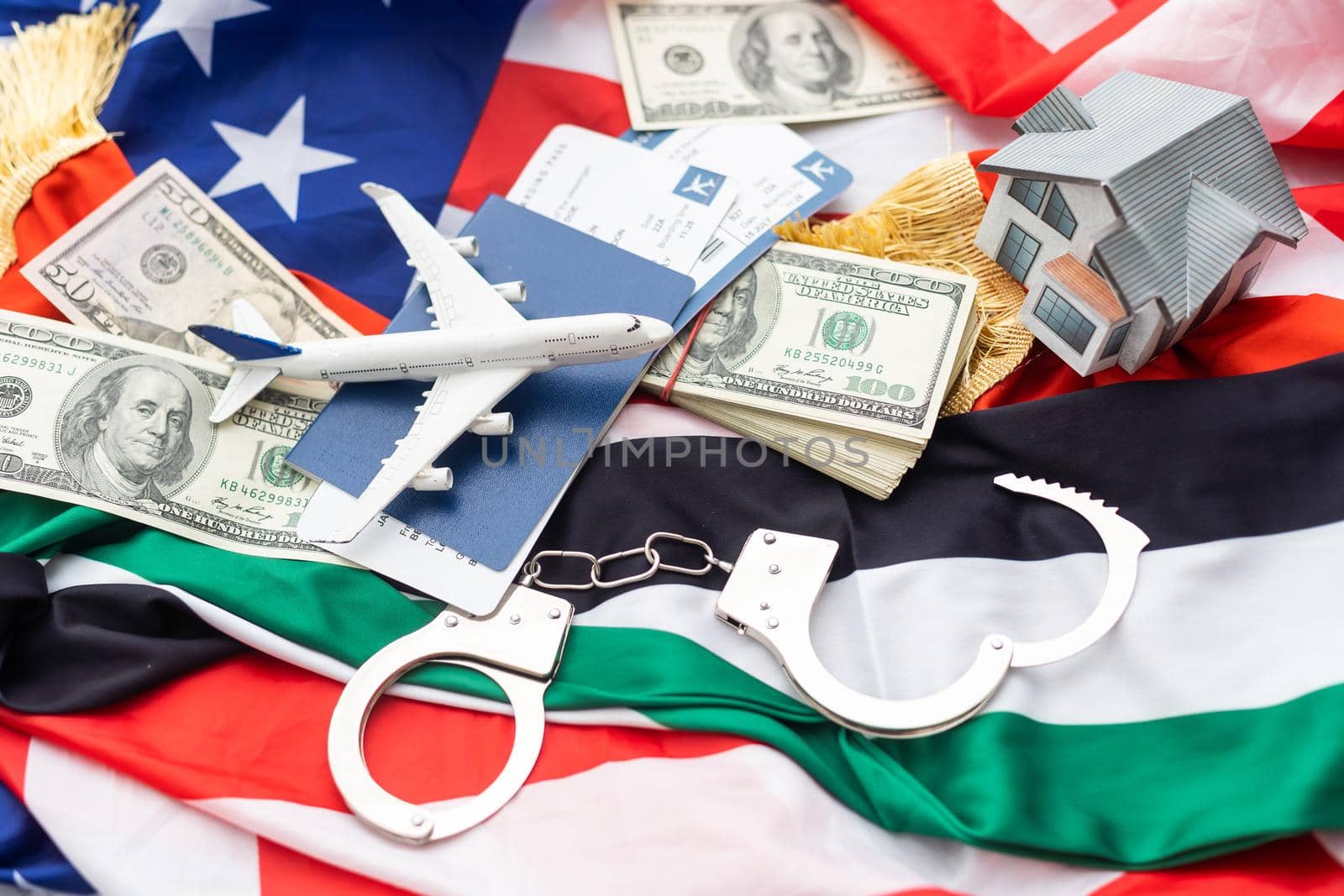metal handcuff, american dollars cash over flag of USA and UAE flags.