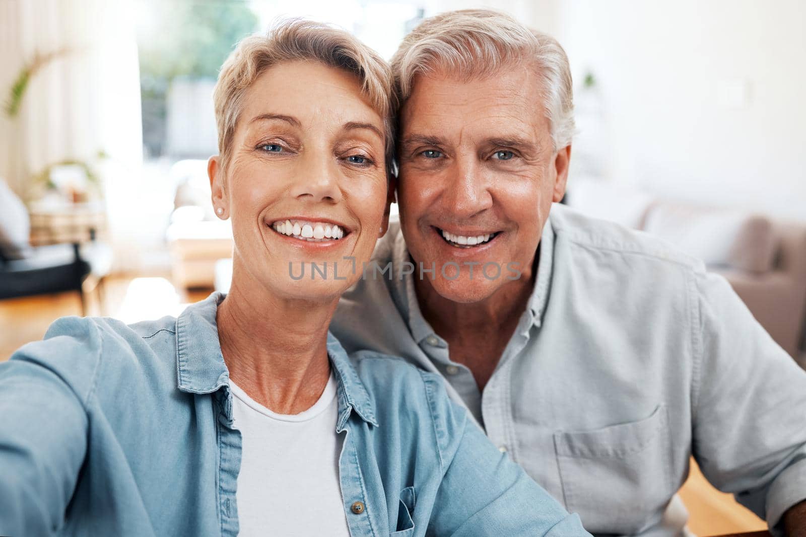 Senior couple selfie portrait in home lounge for love, care and relaxing day together. Faces of smile man, happy woman and retirement people enjoying video call, quality time and close marriage bond by YuriArcurs