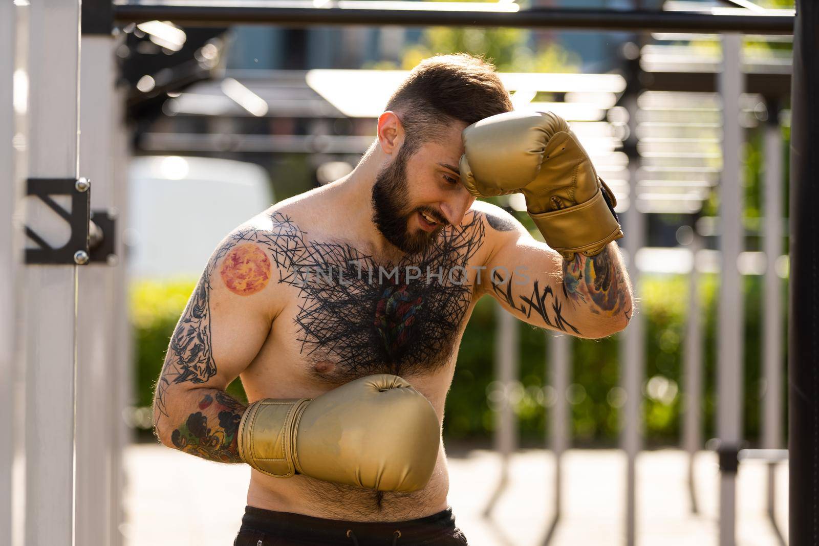 Man in boxing gloves is practicing on an outdoor by Andelov13