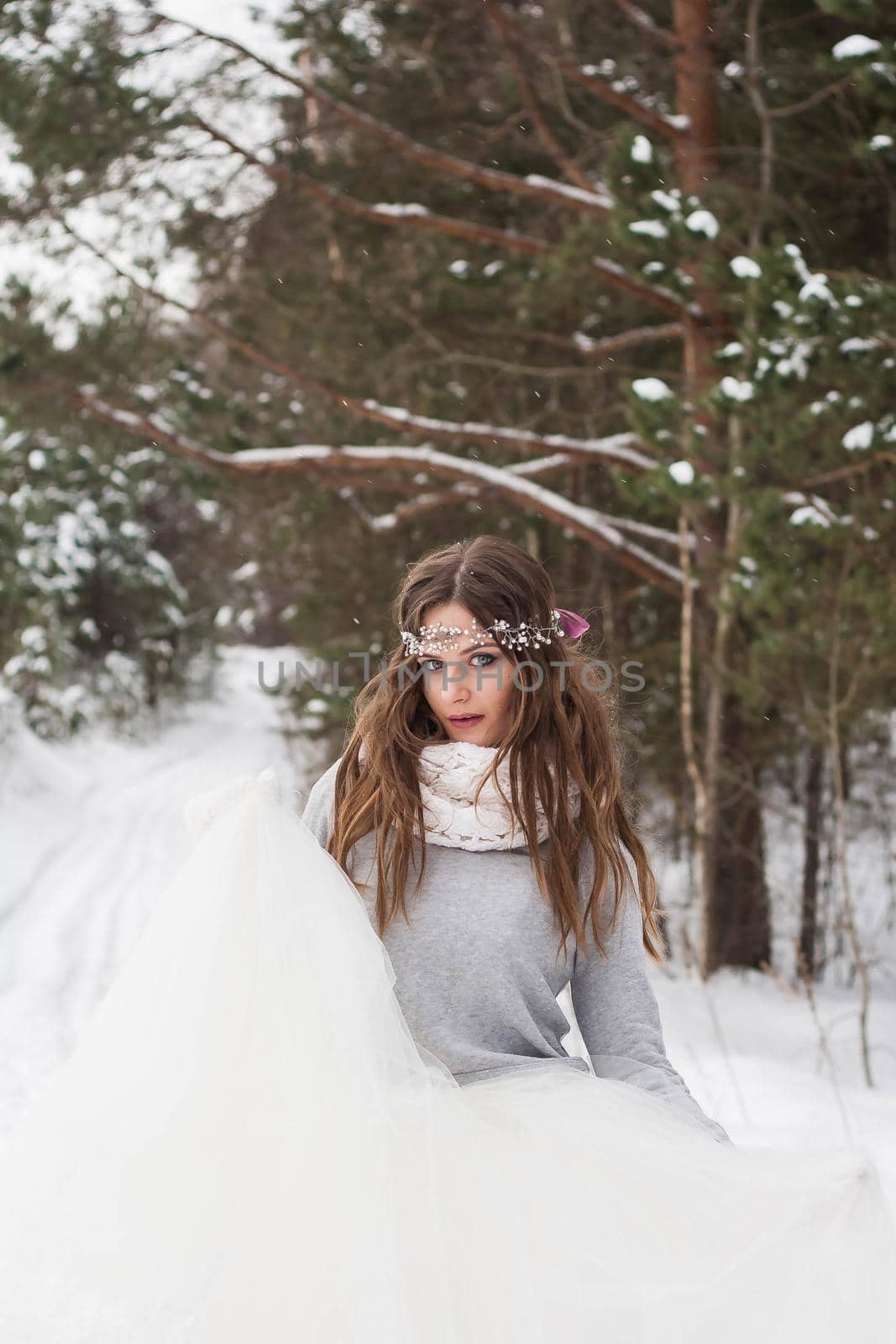 Beautiful bride in a white dress with a bouquet in a snow-covered winter forest. Portrait of the bride in nature by Annu1tochka