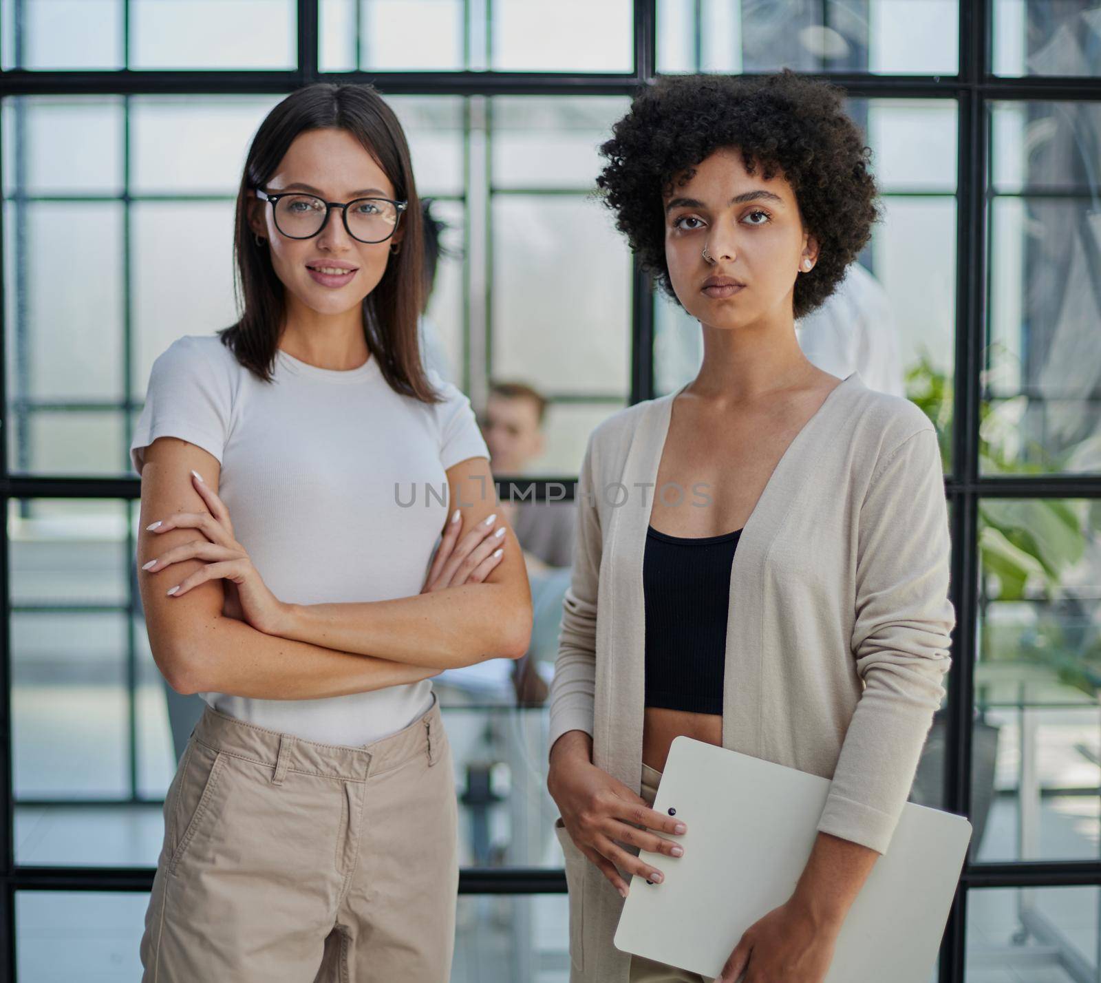 Businesswoman with coworker standing in modern office by Prosto