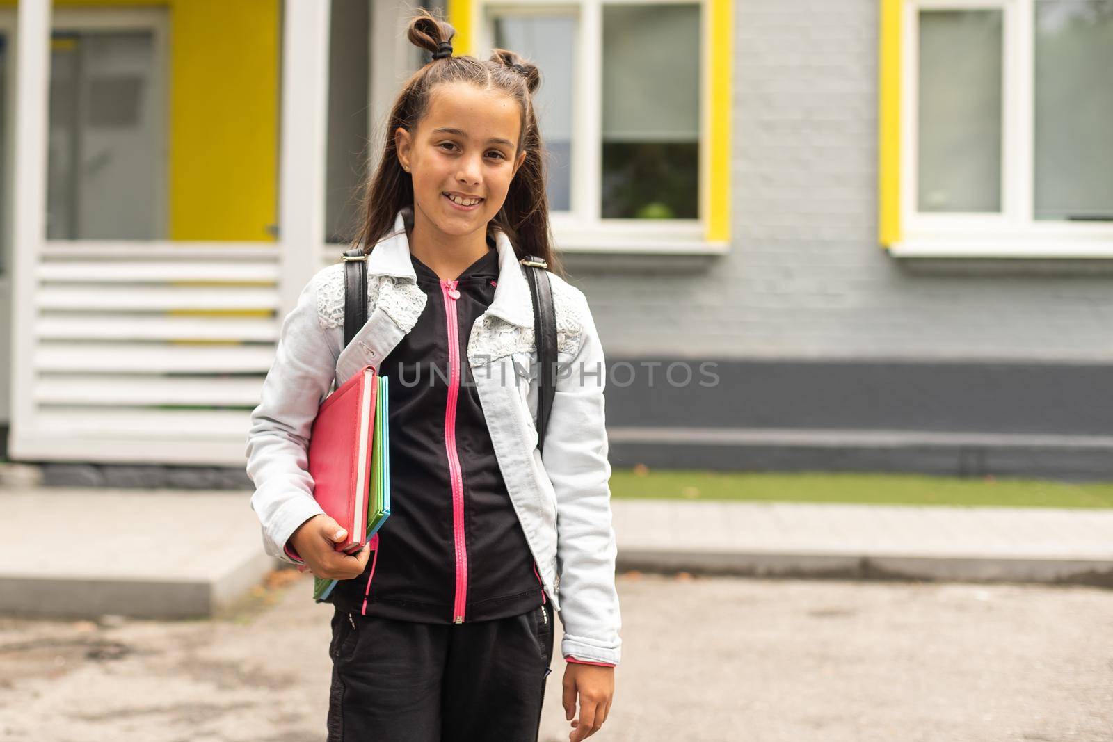 Child going back to school. Start of new school year after summer vacation. Little girl with backpack and books on first school day. Beginning of class.