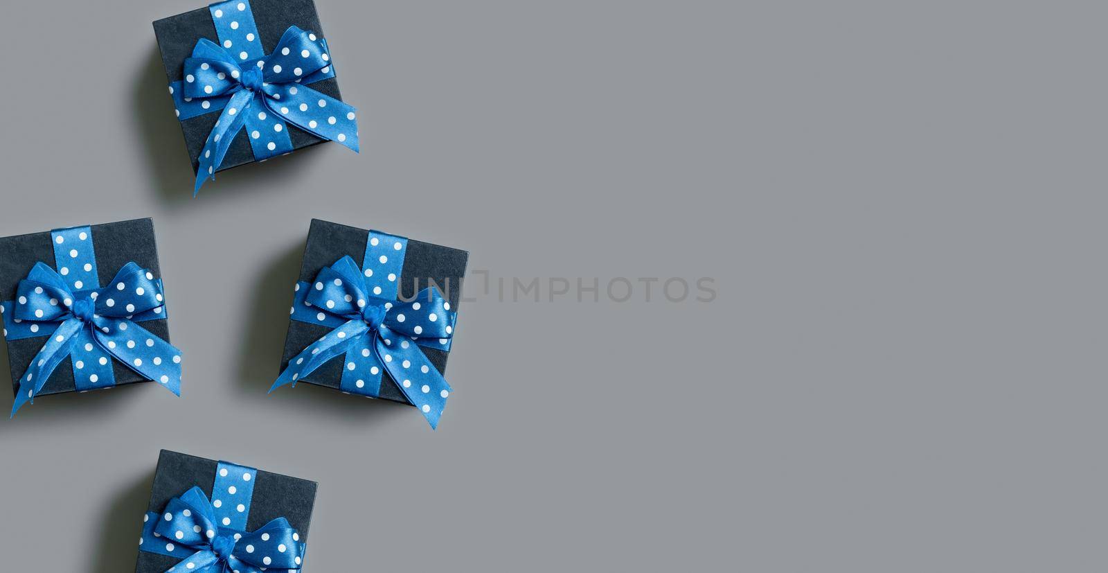 Banner with Black gift boxes with bow flat lay on grey background. View from above. Copy space.