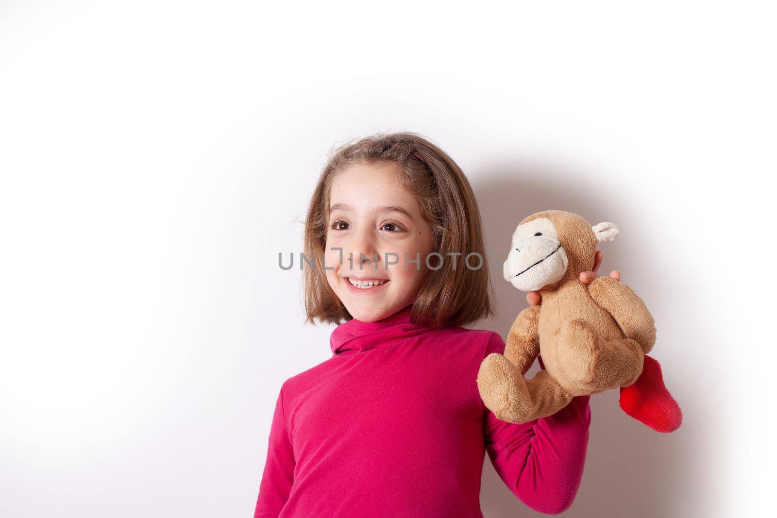 Portrait of cute Little Girl emotional showing her Plush Monkey on white background