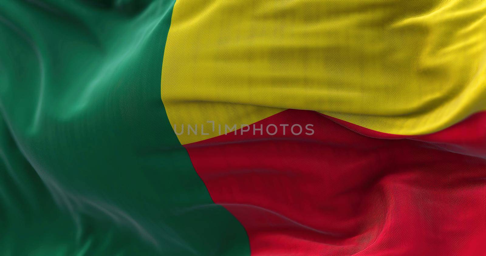Close-up view of the Benin national flag waving in the wind. The Republic of Benin is a country in West Africa. Fabric textured background. Selective focus