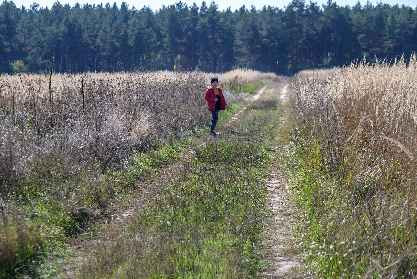 Young boy playing in a field. boy running across the field with his hands in different directions. children fun games. nature leisure with children concept.