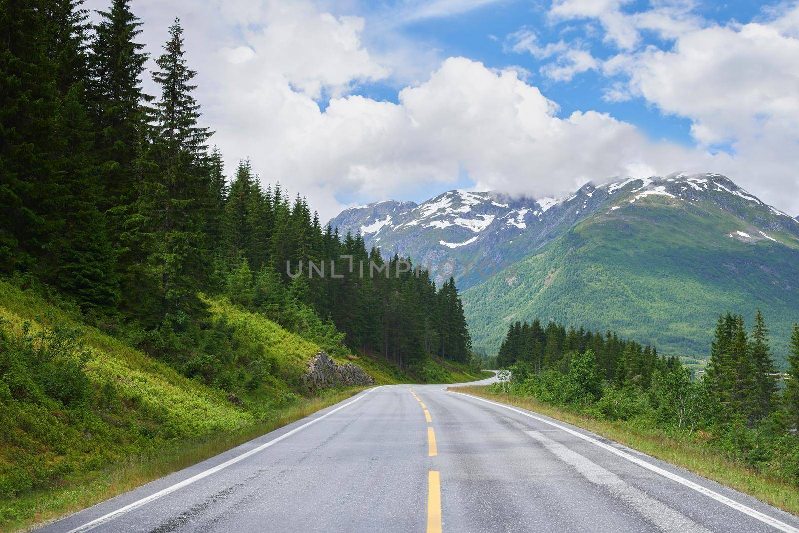 Road mountain, highway and countryside environment with freedom for travel, summer snow in Alaska and street or adventure. Landscape of calm driveway path in nature for transportation on holiday by YuriArcurs