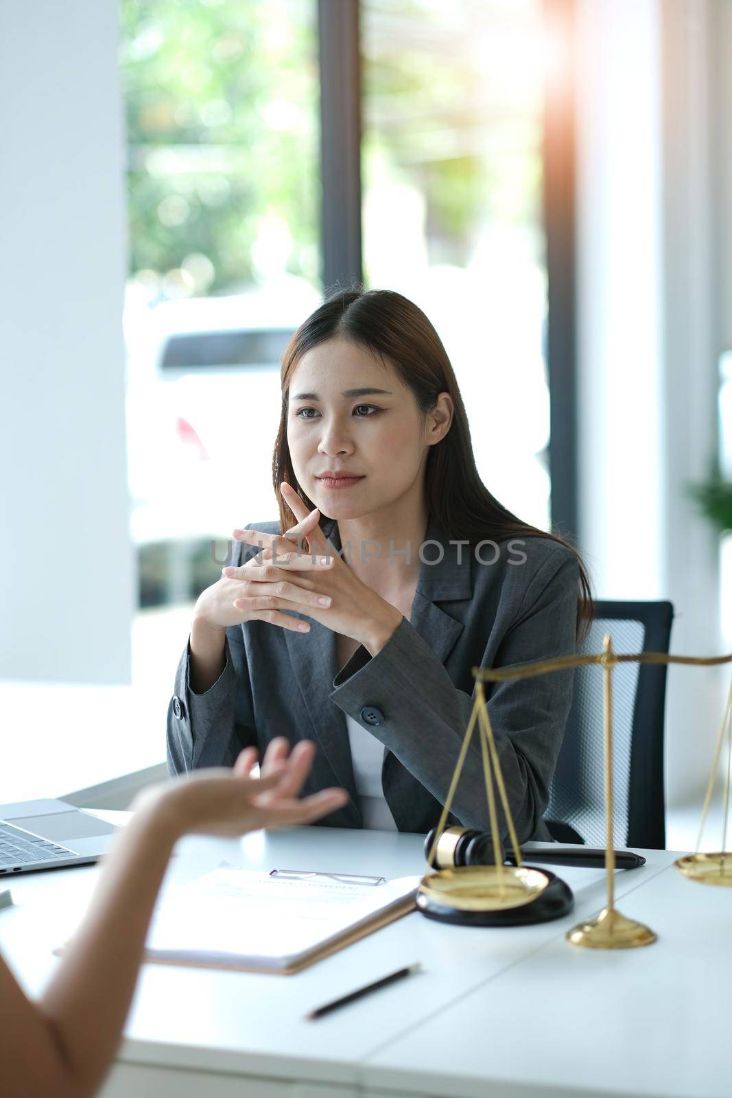 Business woman and lawyers discussing contract papers with brass scale on wooden desk in office. Law, legal services, advice, Justice concept by wichayada