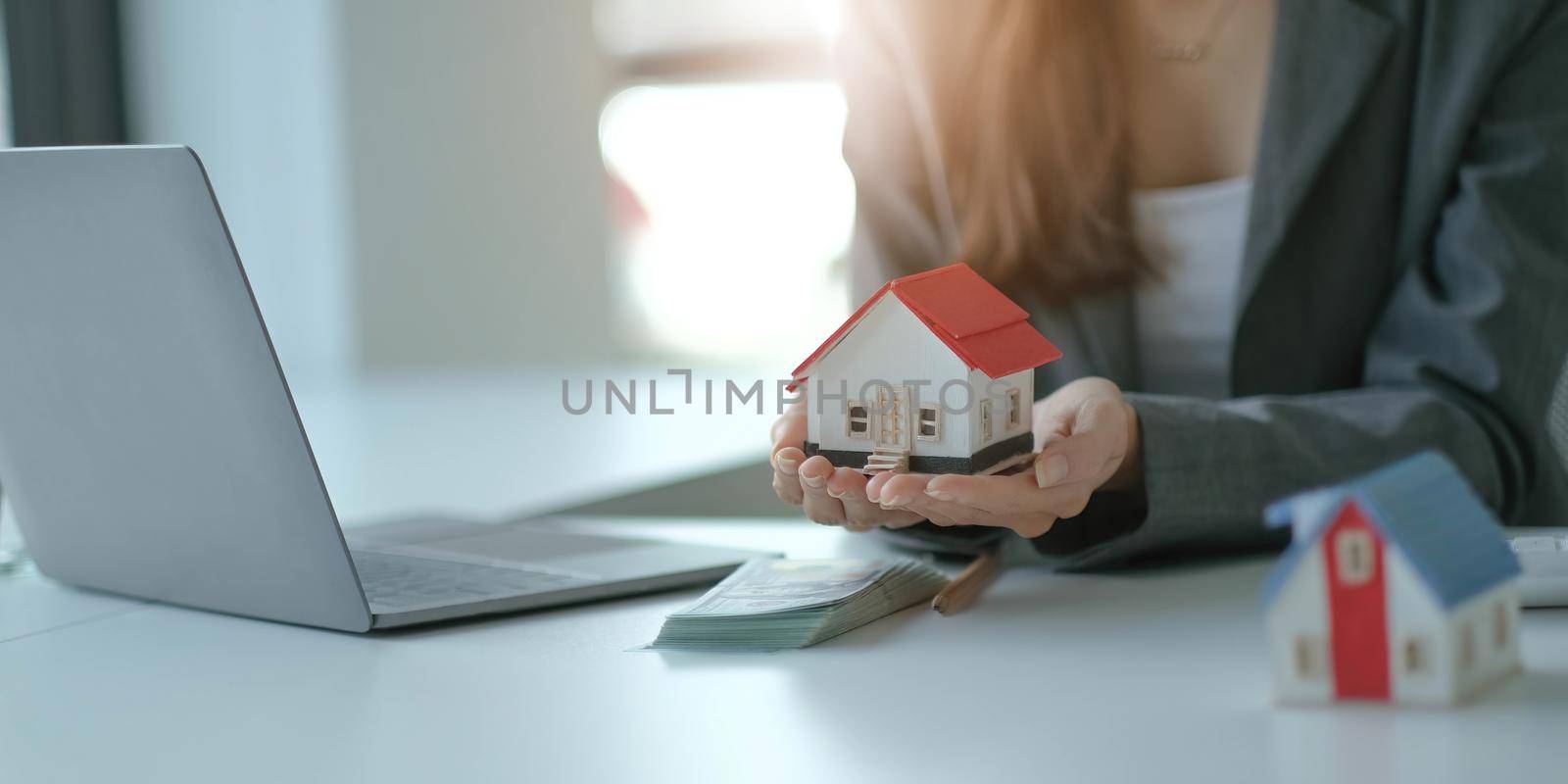 architecture, building, construction, real estate and property concept - close up of hands holding house or home model.