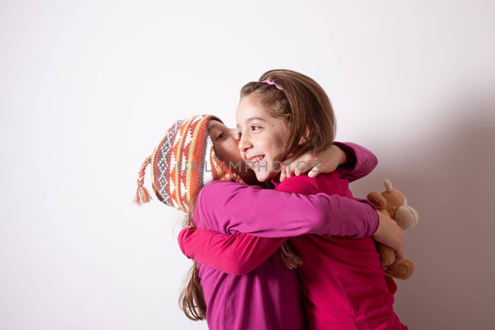 Happy and healthy young little girls hugging and smiling. Best friend kids and children friendship, equality, positive mental health wellness concept