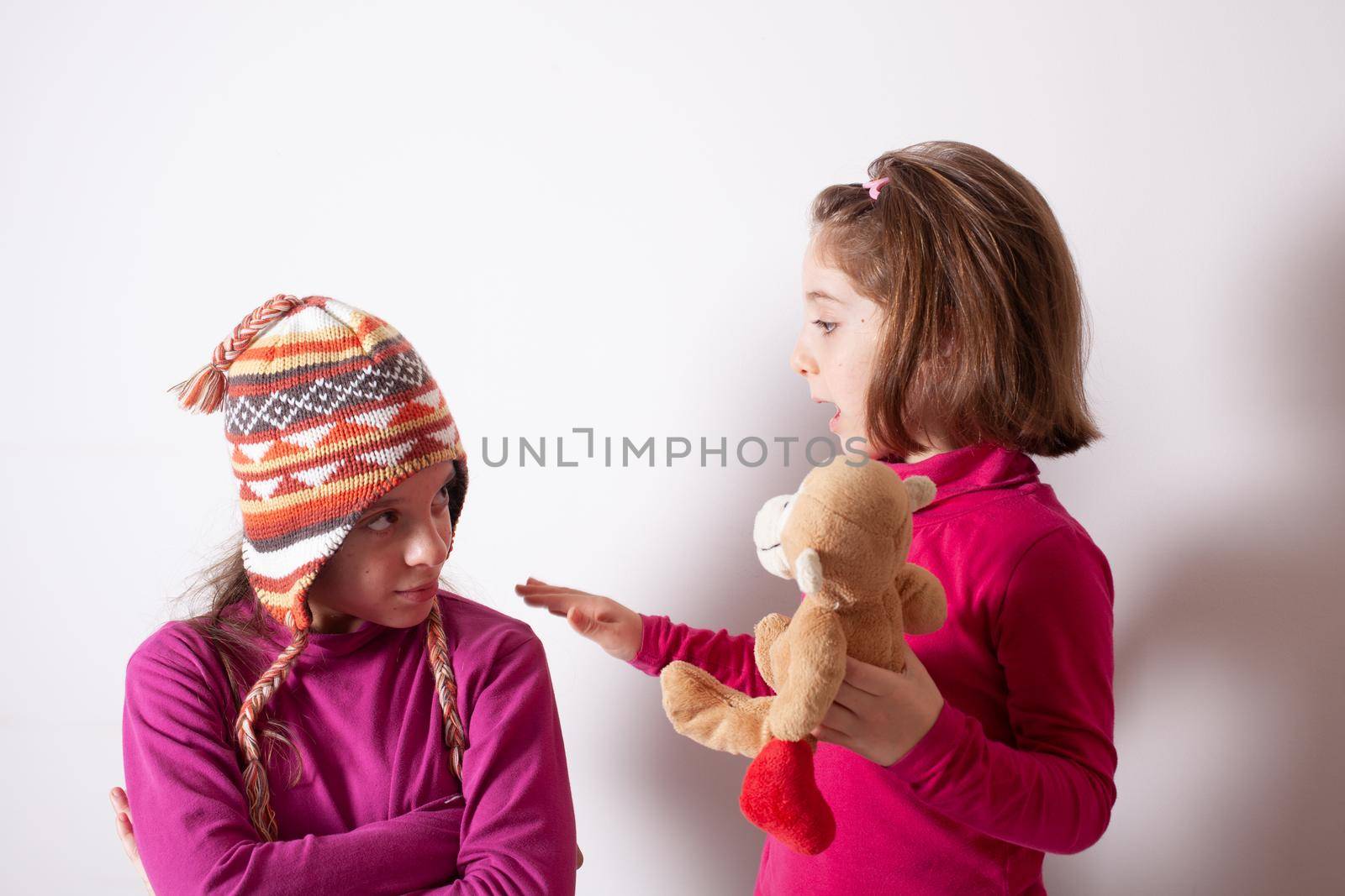 Greedy kids concept. Sisters relations issues. Share toys with friends by bepsimage