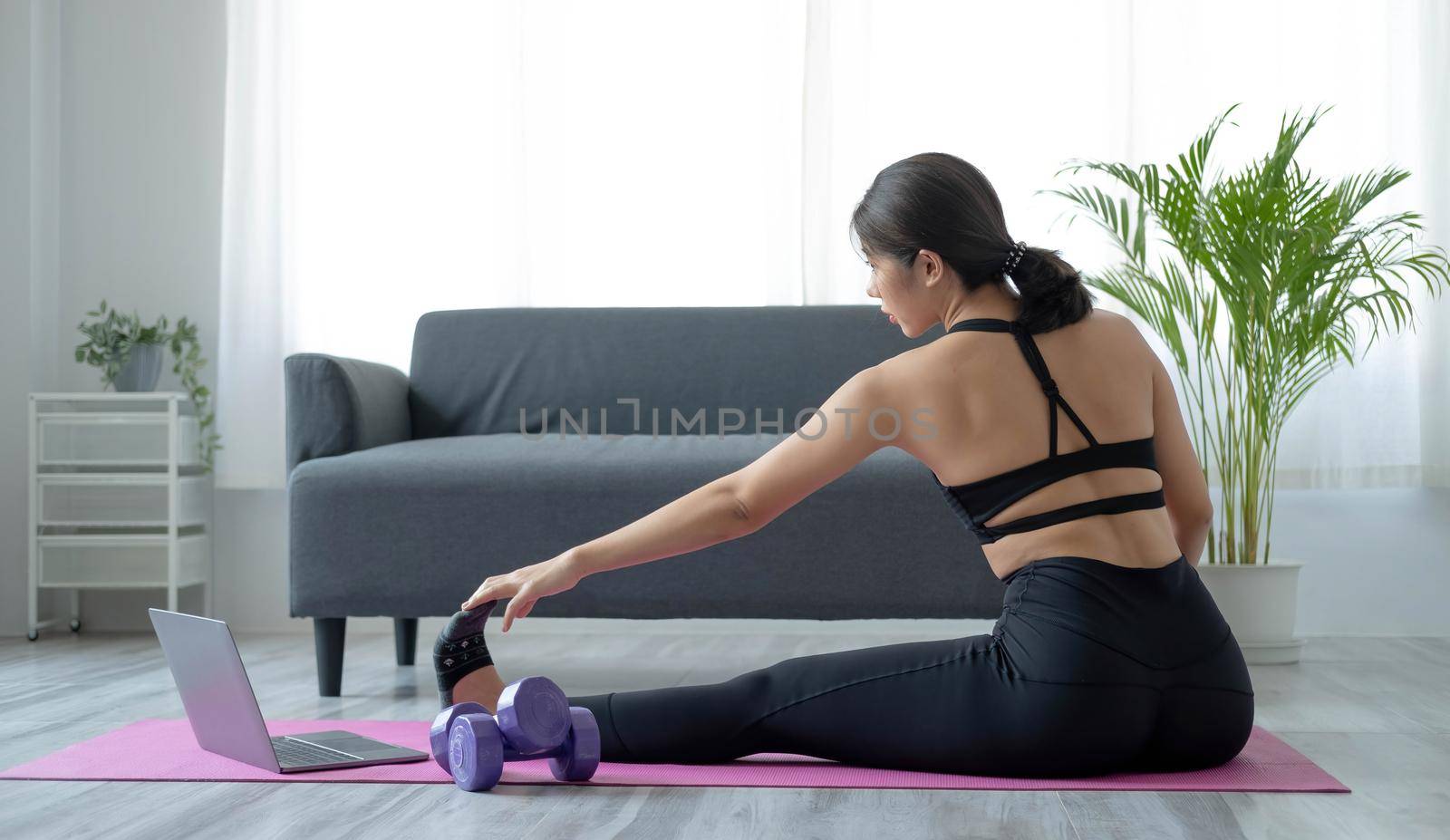 Portrait of young beautiful asian woman stretching warm up exercise workout yoga position at home in living room. Sporty asia girl health care lifestyle. by wichayada