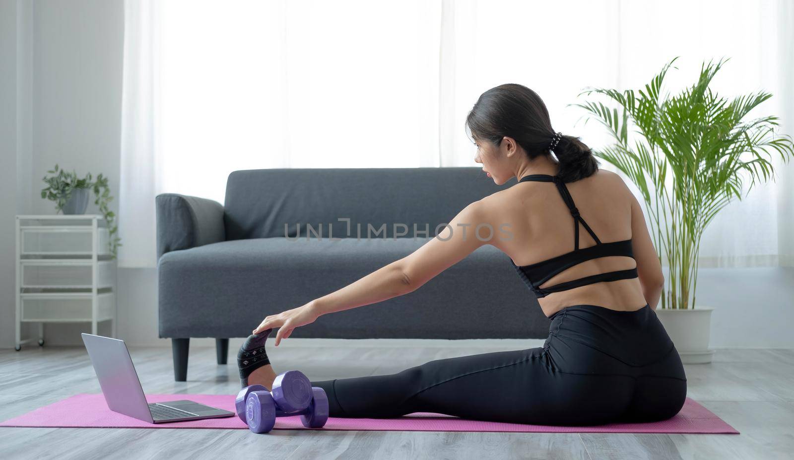 Portrait of young beautiful asian woman stretching warm up exercise workout yoga position at home in living room. Sporty asia girl health care lifestyle