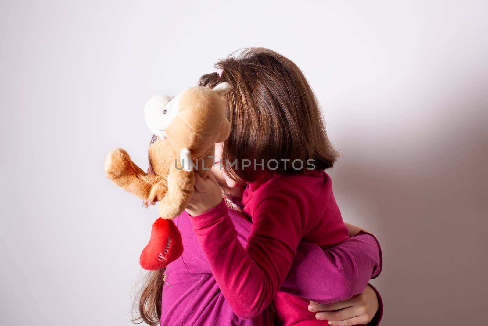 Happy and healthy young little girls hugging and smiling by bepsimage