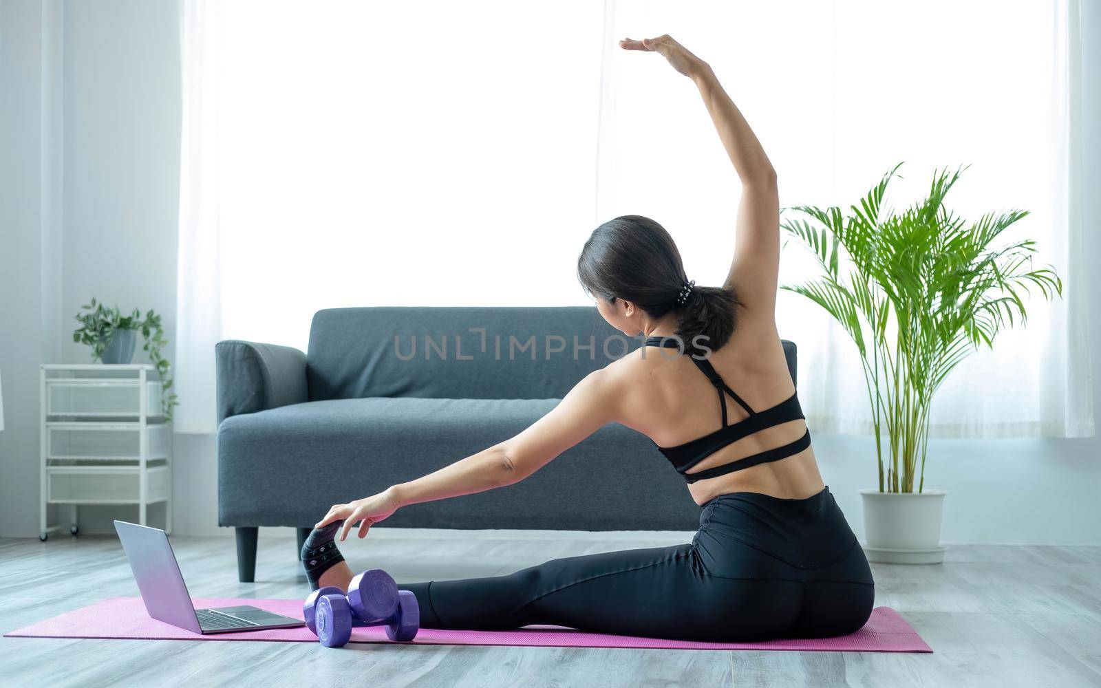 Portrait of young beautiful asian woman stretching warm up exercise workout yoga position at home in living room. Sporty asia girl health care lifestyle