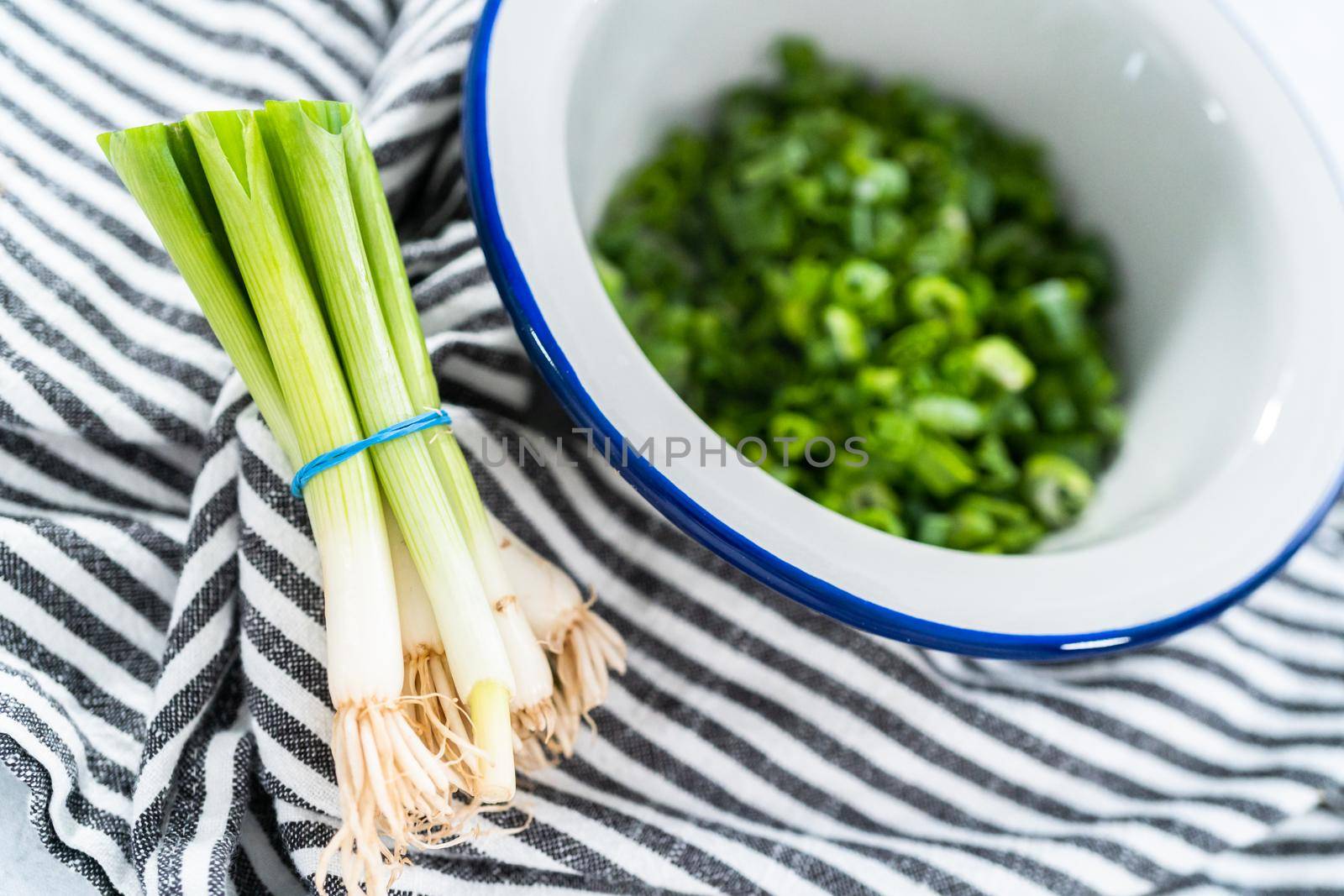 Chopped organic green onions in a metal bowl.