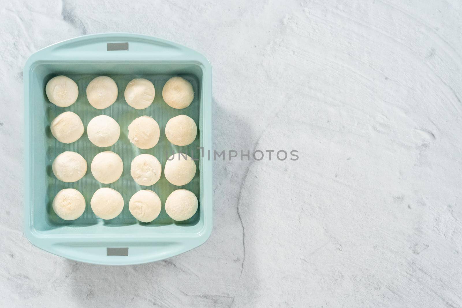 Flat lay. Baking dinner rolls from the premade frozen dough in the baking pan.