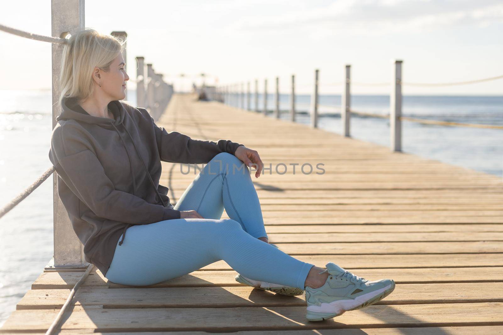 Female tourist walk and chill on wooden bridge as surround sea and beach.