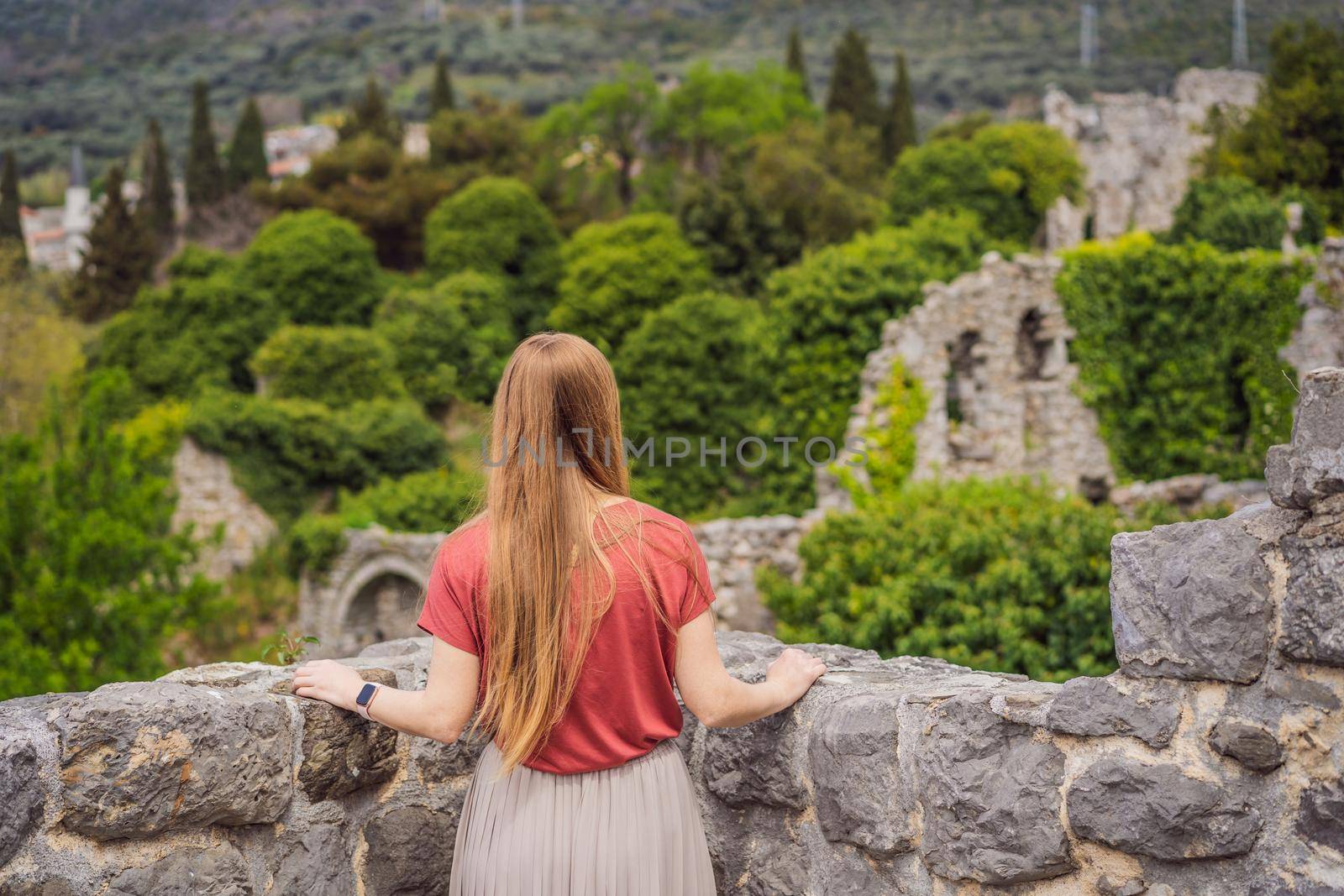 Woman tourist walks through the old town of Bar in Montenegro. Happy tourist walks in the mountains. Suburbs of the city of Bar, Montenegro, Balkans. Beautiful nature and landscape.