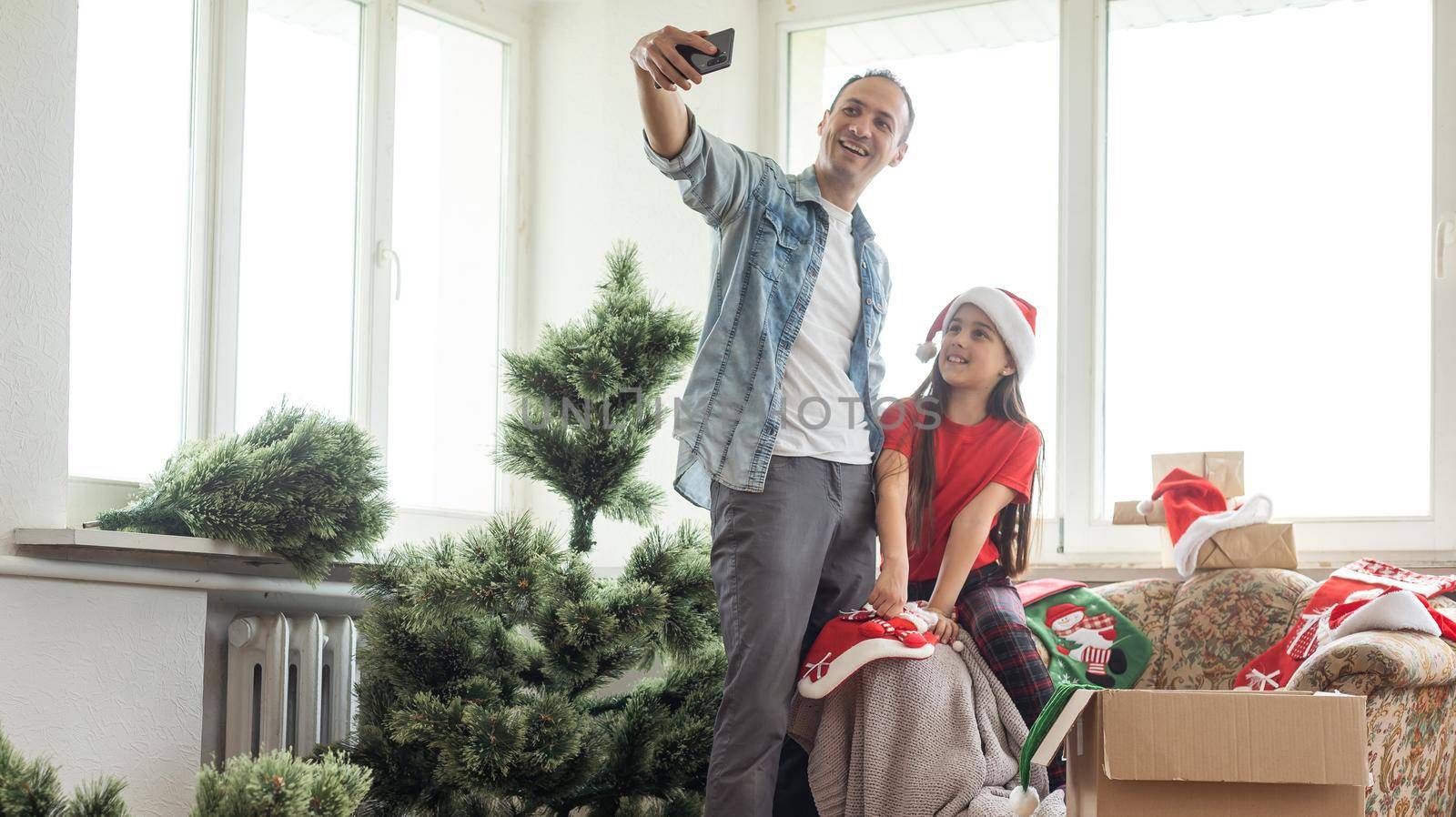 father and daughter install an artificial Christmas tree.