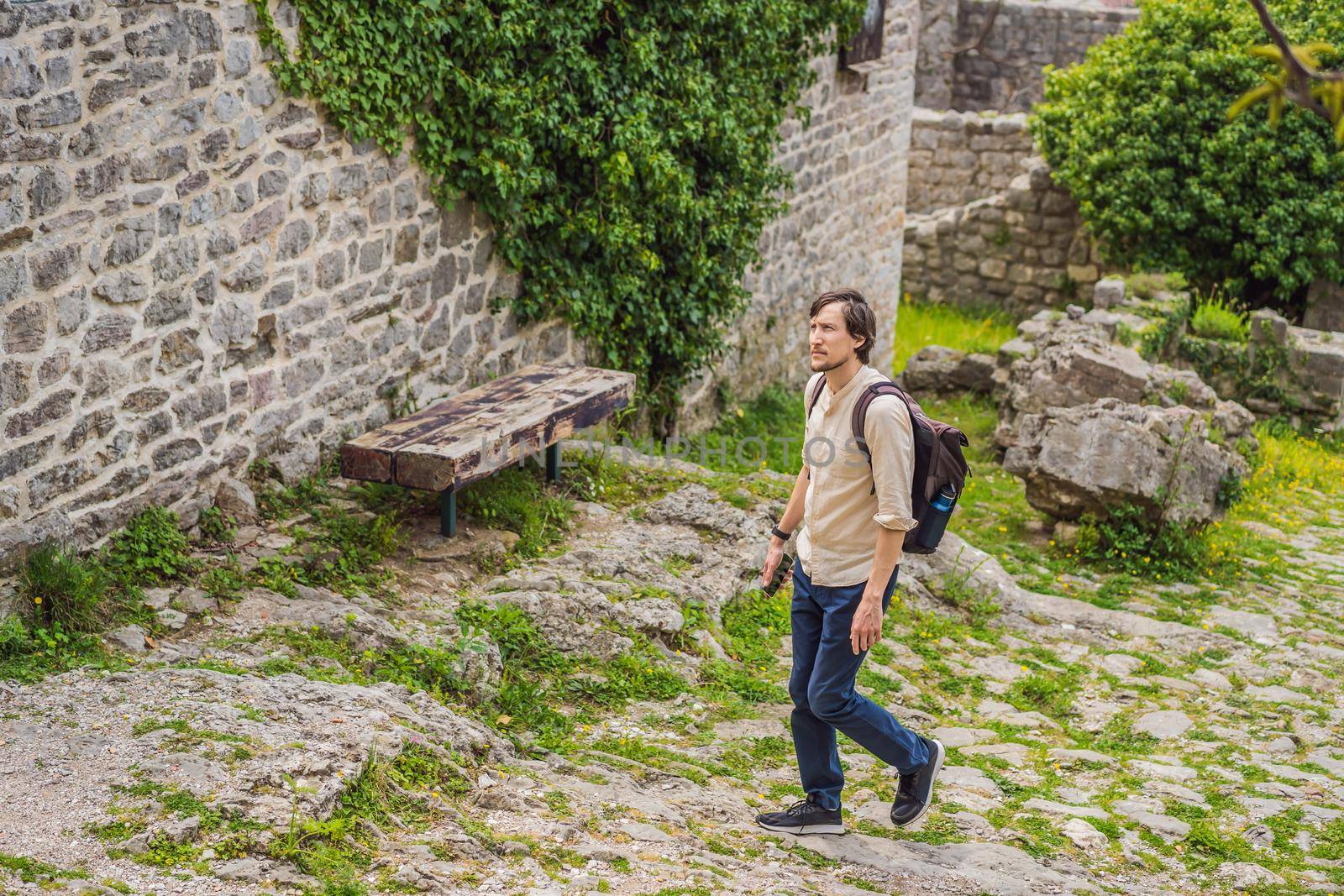 Man tourist walks through the old town of Bar in Montenegro. Happy tourist walks in the mountains. Suburbs of the city of Bar, Montenegro, Balkans. Beautiful nature and landscape.