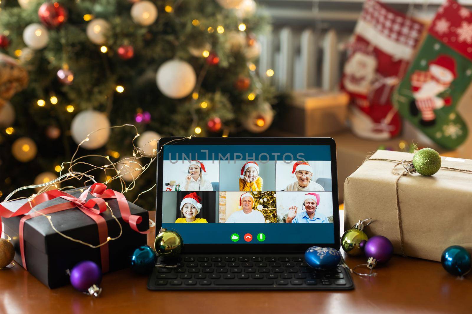 Big family singing christmas song at tablet camera during online video call. Smiling parents and children. Joyful family congratulating relatives with happy new year online.