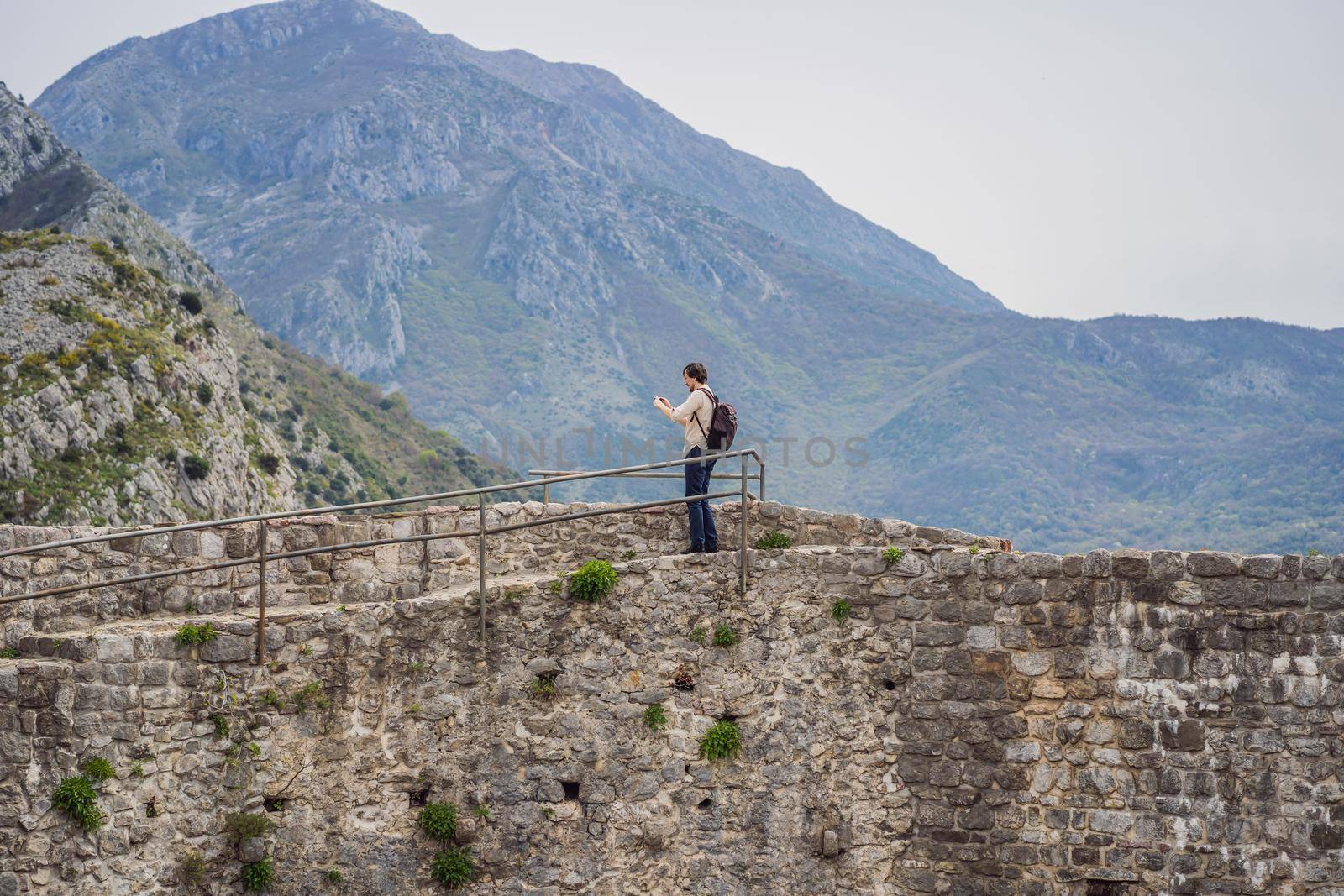 Man tourist walks through the old town of Bar in Montenegro. Happy tourist walks in the mountains. Suburbs of the city of Bar, Montenegro, Balkans. Beautiful nature and landscape.