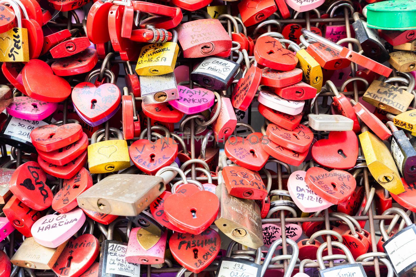 Verona, Italy - June 2022: background of heart-shaped locks on a wall, symbol of love forever. by Perseomedusa