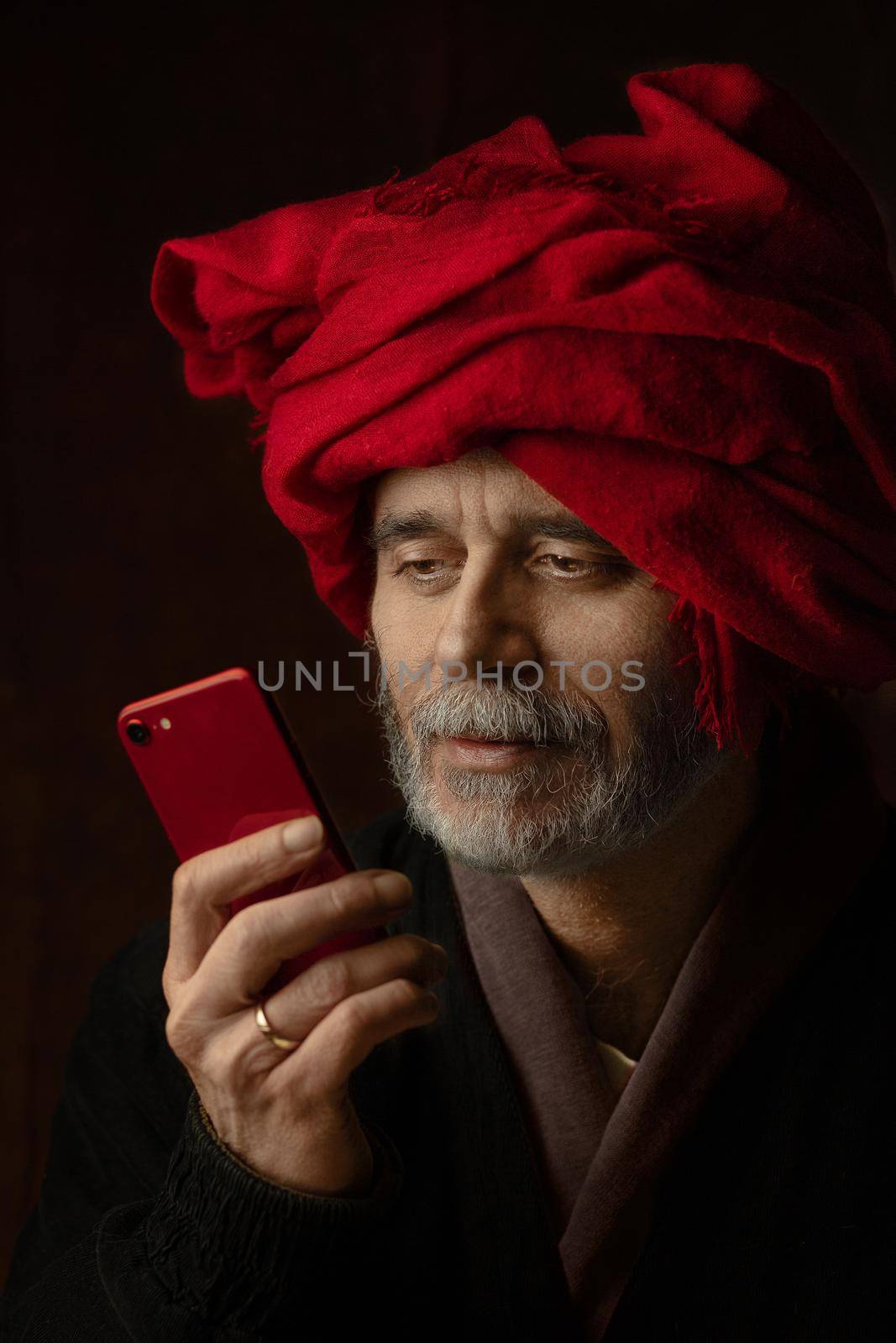 homage to Jan van Eyck's painting a man in a red turban - a photo portrait of a 21st century man with a red mobile phone matching the color of the turban by Costin