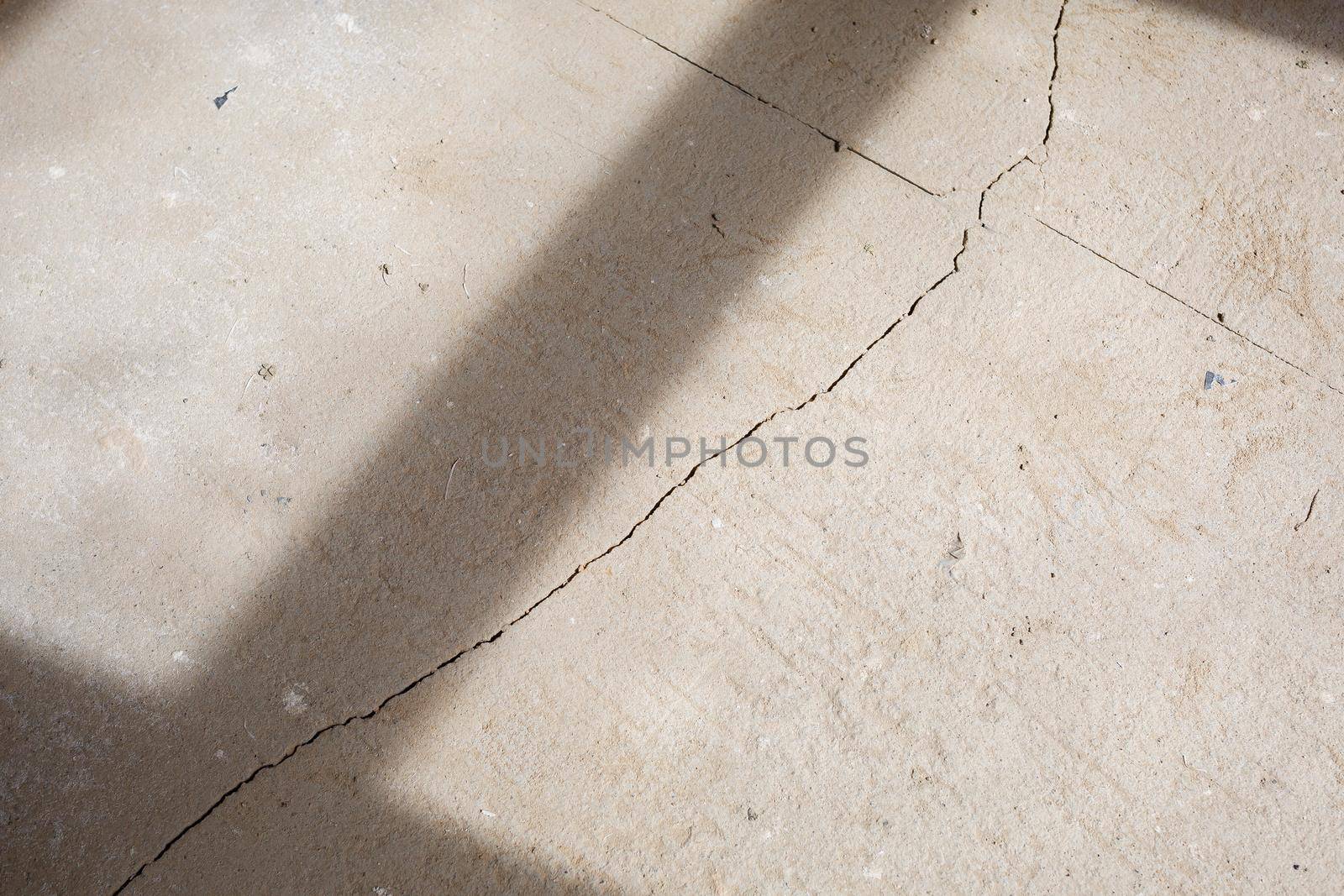 Cracks in the concrete cement screed on the floor after repair. The concrete surface texture is covered with web cracks. Gray stone background