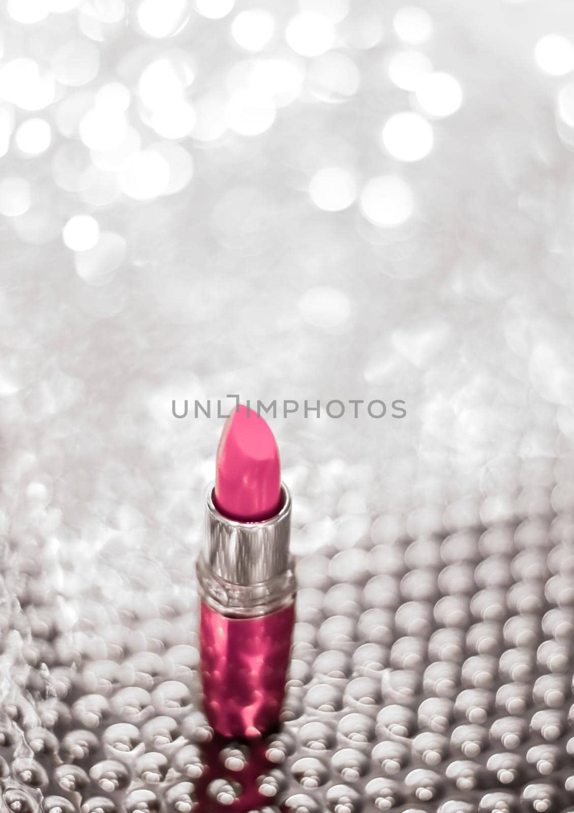 Cosmetic branding, sale and glamour concept - Pink lipstick on silver Christmas, New Years and Valentines Day holiday glitter background, make-up and cosmetics product for luxury beauty brand